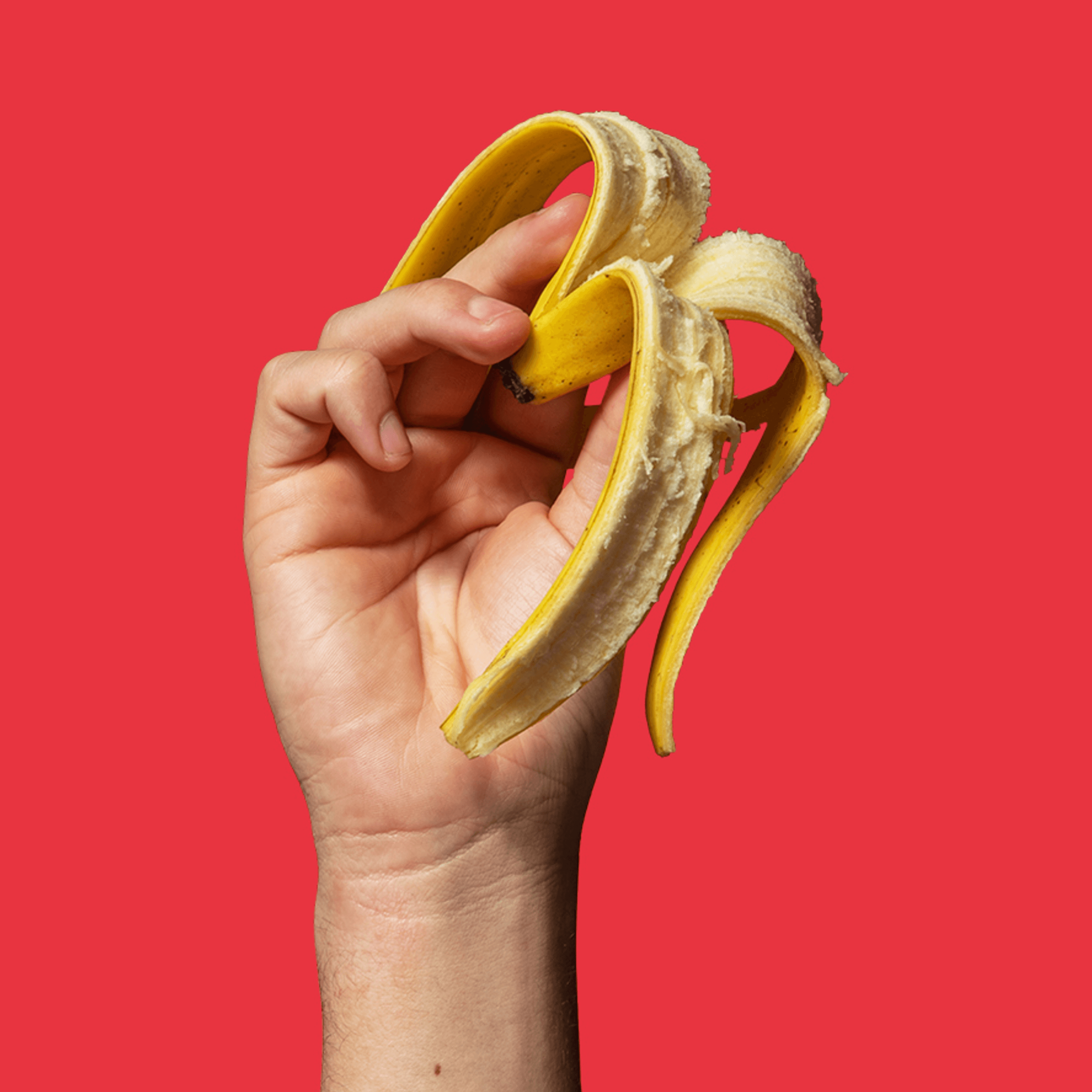 Llaw gwyn yn dal croen banana