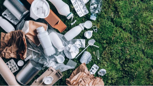 A selection of recyclable household packaging on some grass by shutterstock.com/g/j.chizhe