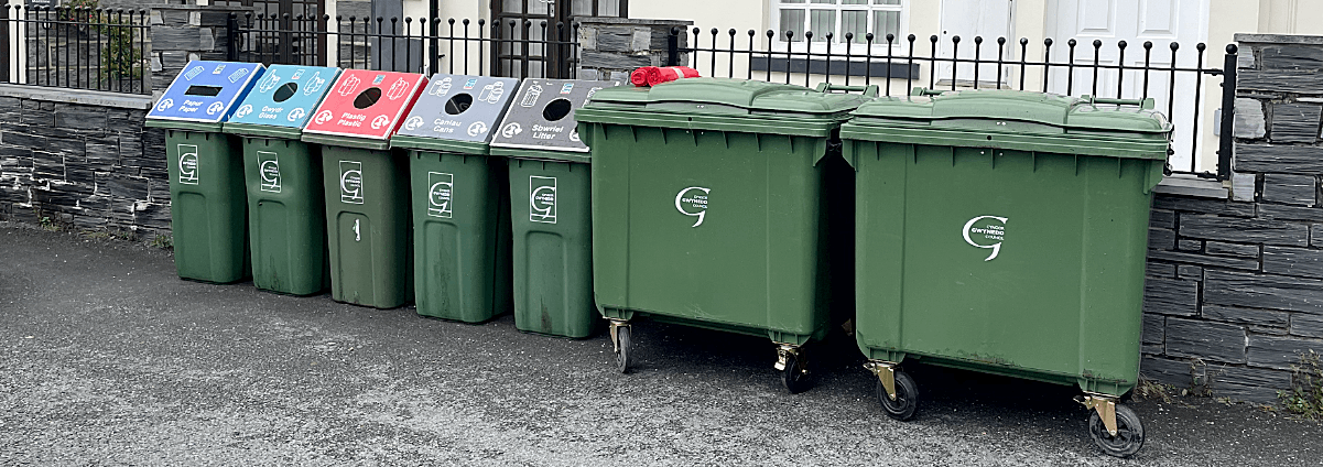 A photo of many outdoor recycling bins outside a workplace building